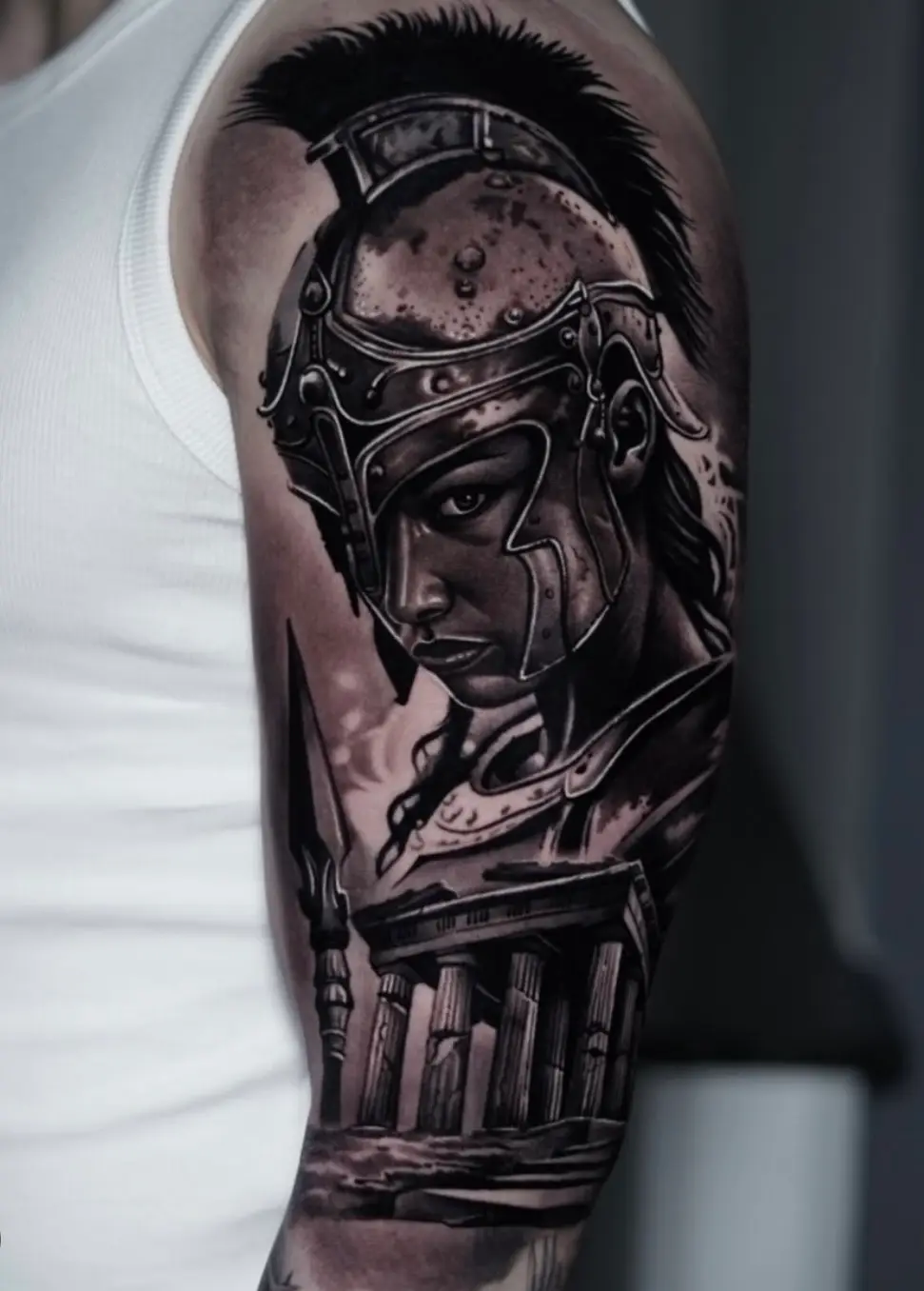 Ein detailliert Black and Gray im Realismus auf einem Männer Oberarm, dass die griechische Kriegsgöttin  Athena mit und antike 