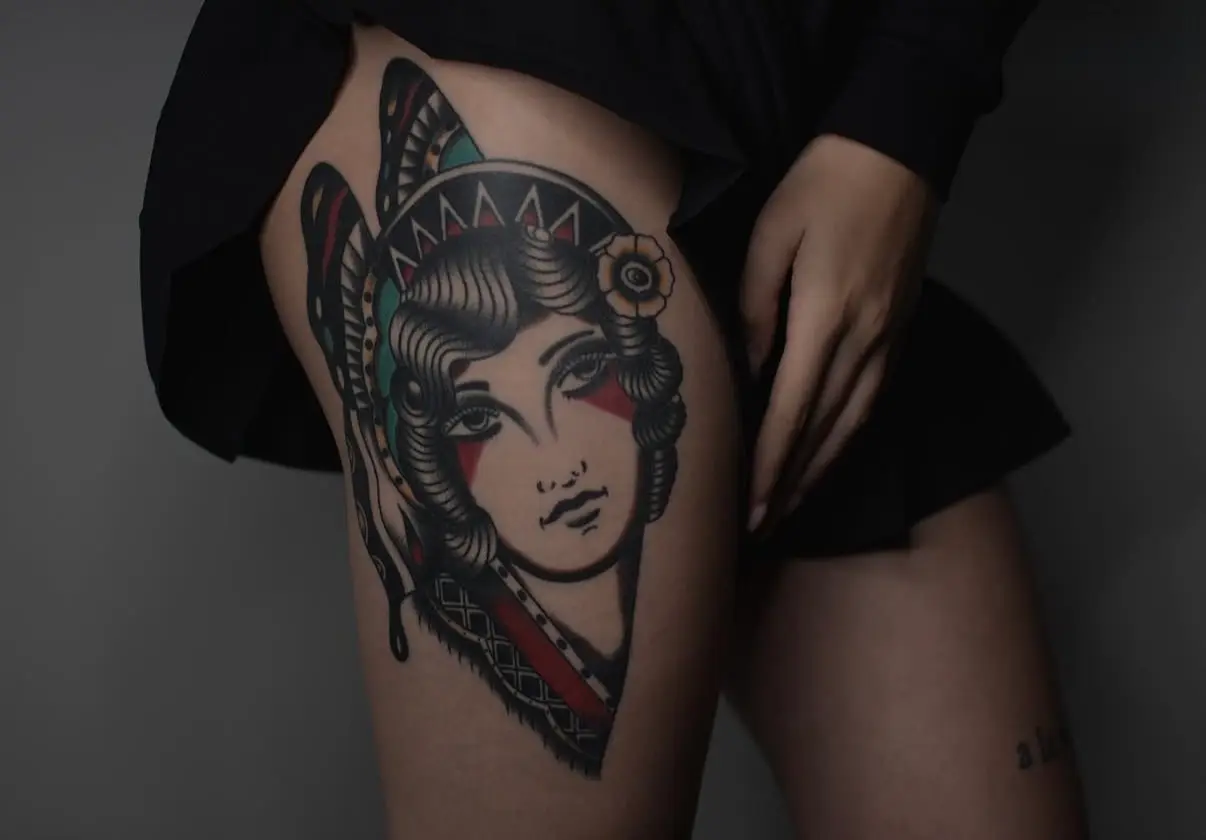 Old School Tattoo einer Schmetterlingsfrau auf dem Bein